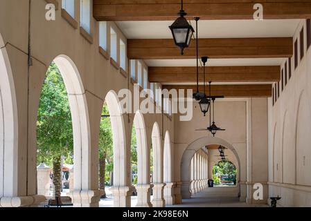 Lightner Museum, die historische Kolonnade aus weißem Zement im spanischen Stil, verfügt über hängende schwarze Leuchten und Holzbalken mit kleinen Fenstern über dem Stockfoto