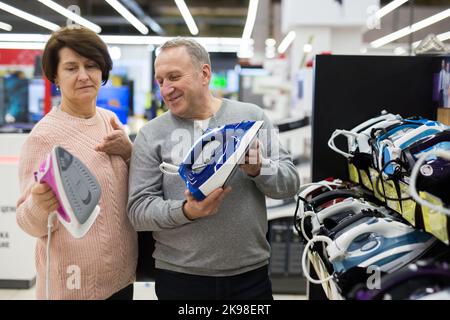 Glückliche Ehegatten des reifen Alters wählen ein Eisen Stockfoto