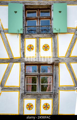 Simmetrische Fenster eines traditionellen elsässischen Hauses im Ecomuseum Elsass in der Stadt Mulhouse, Elsass, Frankreich Stockfoto