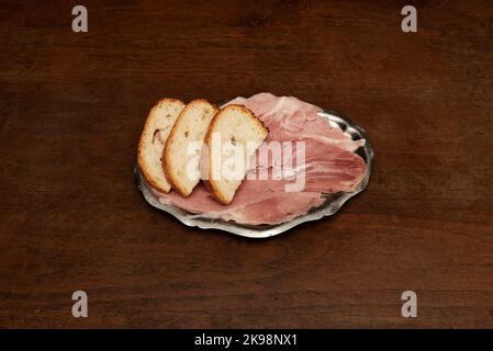 Galizische Tapa von lacon, gekocht mit Dorfbrotscheiben auf einem Metalltablett Stockfoto