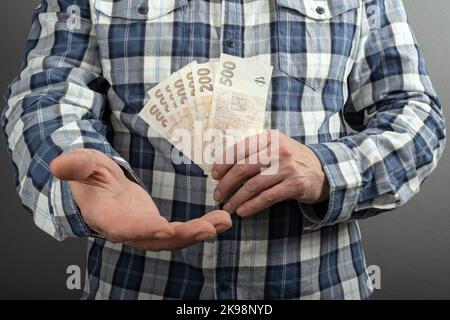 Zählung der tschechischen Krone in verschiedenen nominalen Banknoten CZK. Halten Sie ein kleines Bargeld bereit. Tschechische Finanzkonzept. Nahaufnahme mit selektivem Fokus. Stockfoto