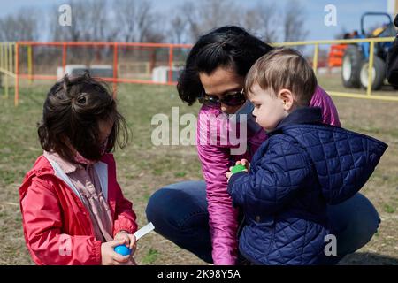 Maskierte Mutter mit Kindern auf dem County Fair Stockfoto