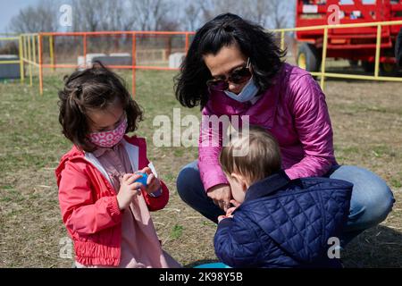 Maskierte Mutter mit Kindern auf dem County Fair Stockfoto