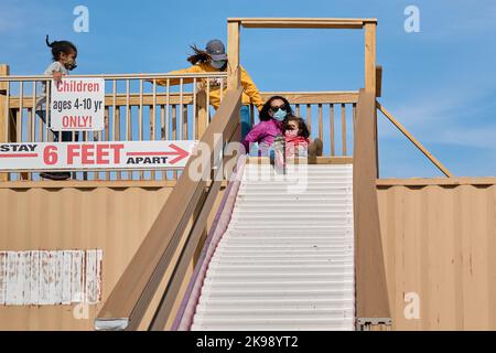 Mutter und Tochter gehen auf dem Bezirksmarkt in die Sllide Stockfoto