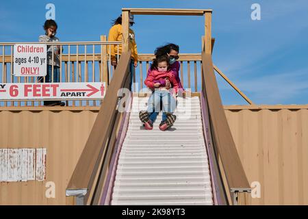 Mutter und Tochter gehen auf dem Bezirksmarkt in die Sllide Stockfoto