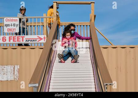 Mutter und Tochter gehen auf dem Bezirksmarkt in die Sllide Stockfoto