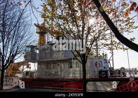 An einem Herbsttag wird eine kanadische Küstenwache am Hafen von Toronto vor Anker gesehen, und die Morgensonne scheint durch. Stockfoto