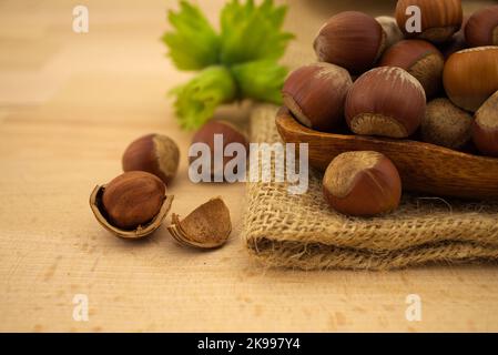 Frische rohe, ungeschalte Haselnüsse in einer Holzschale mit selektiver Fokusansicht Stockfoto