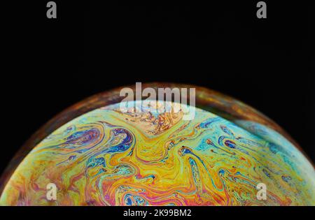 Virtual Reality Raum mit abstrakten multicolor psychedelischen Planeten. Nahaufnahme Seifenblase wie ein außerirdischer Planet auf schwarzem Hintergrund Stockfoto