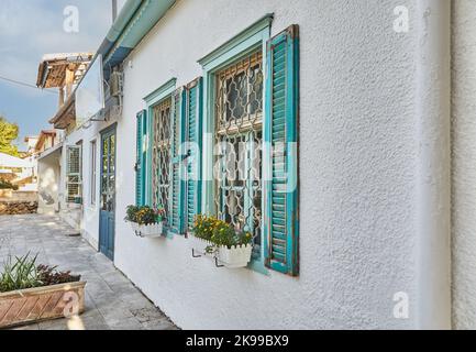 Holzfenster und Fensterläden im Haus bei Sonnenuntergang blau gestrichen Stockfoto