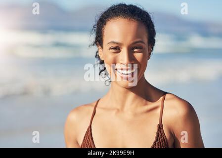 Es fühlt sich sicher gut an. Eine schöne junge Frau, die den Tag am Strand verbringt. Stockfoto