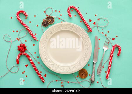 Weihnachtliche Tischeinstellung mit Zuckerstöcken auf farbigem Hintergrund Stockfoto