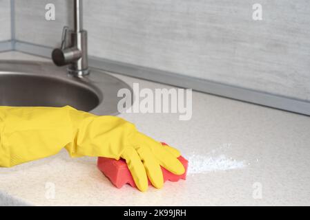 Reinigung. Frau Handschuhe Hände Reinigung Küche. Reinigung des Wohntisches, Desinfektion des Küchentischs, Oberfläche mit rotem Schwamm. Deep Cleaning Service. Copy Spa Stockfoto