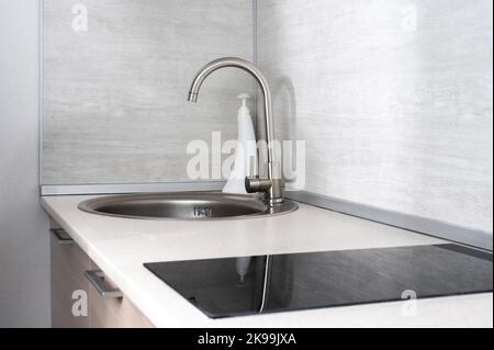 Moderne, weiße Küche, saubere Inneneinrichtung. Nahaufnahme. Wirtschaftliche Küche mit minimalem Design. Platz zum Kopieren Stockfoto
