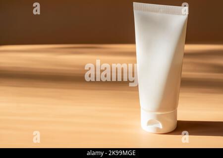 Weiße kosmetische Creme-Tube, Balsam Glas Mockup auf beigem Hintergrund. Leeren Behälter für das Produkt auffüllen. Körper- und Gesichtspflege. Stockfoto