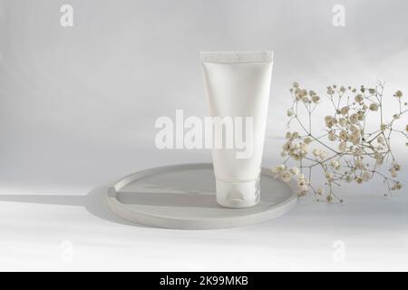 Weiße kosmetische Creme-Tube, Balsam-Glas-Mockup auf runden Betonschale auf weißem Hintergrund. Leeren Behälter für das Produkt auffüllen. Körper- und Gesichtspflegekonzept Stockfoto