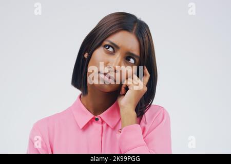 Alles liegt in deinem Kopf. Studioaufnahme einer jungen Frau, die vor grauem Hintergrund nachdenklich aussieht. Stockfoto