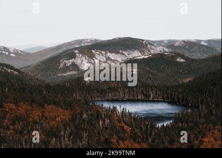 Moody Landschaft, See umgeben von Hügeln und Bäumen mit bunten Blättern im Grands-Jardins National Park, Kanada Stockfoto