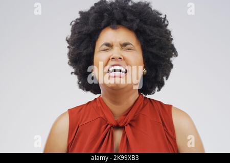 Dies ist der schlimmste Tag aller Zeiten. Studioaufnahme einer jungen Frau, die weint, während sie vor einem grauen Hintergrund steht. Stockfoto
