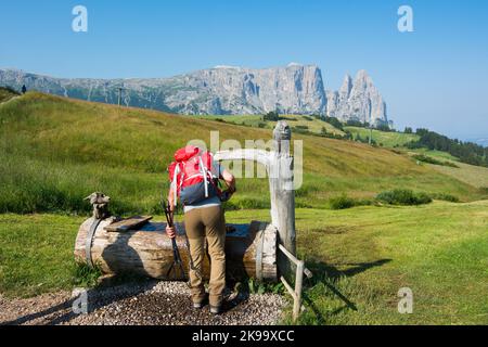 Kastelruth, Italien - 22. Juli 2022: Seiser Alm oder Seiser Alm, Dolomiten. Schlernberg und Holzbrunnen. Trentino Alto Adige Südtirol, Ita Stockfoto