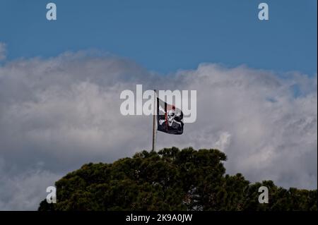 Die fröhliche roger-Piratenflagge fliegt stolz gegen die Wolken. Stockfoto