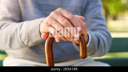 Halten Sie sich immer an die Dinge fest, die Sie am meisten brauchen. Nahaufnahme eines nicht erkennbaren älteren Mannes, der sich draußen an seinem Spazierstock festhält. Stockfoto