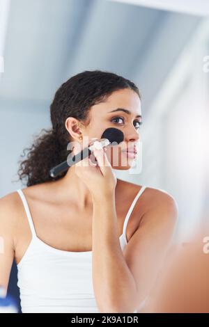 Wachen Sie auf für Make-up. Eine junge Frau, die Make-up auf ihre Wangen im Badezimmer zu Hause. Stockfoto