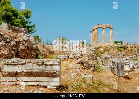Ein Blick auf die archäologische Stätte des antiken Korinths in Griechenland, wobei die Überreste des Apollontempels im Hintergrund hervorgehoben werden Stockfoto