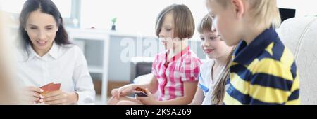 Kinder halten Spielkarten, Spiel mit den Eltern zu Hause, Spiele für die Entwicklung Stockfoto