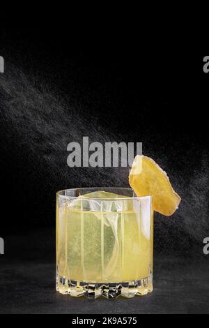 Penicillin-Cocktail in einem altmodischen Glas auf dunklem Beton Stockfoto