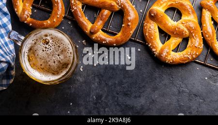 Frisch gebackene hausgemachte Brezeln und Bier vom Fass. Flach liegend mit Kopierplatz Stockfoto