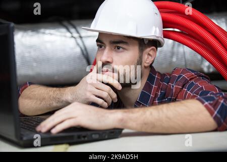 Techniker, der die Fußbodenheizung instandgesetzt hat Stockfoto