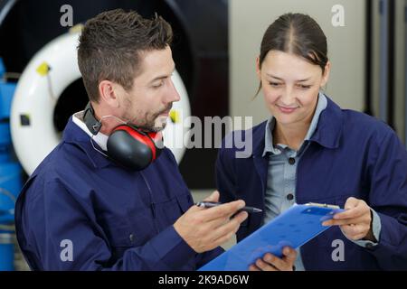 Weibliche aero Engineer, der an Helikopter im Hangar Stockfoto