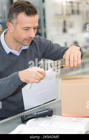 Mann heftend Papier im Büro Stockfoto