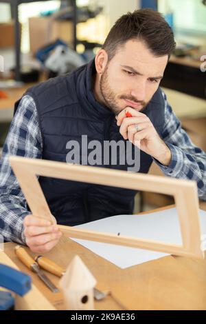 Der Schrankbauer baut einen Holzrahmen Stockfoto