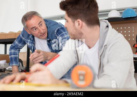 Ingenieur zeigt dem Lehrling, wie er arbeitet Stockfoto