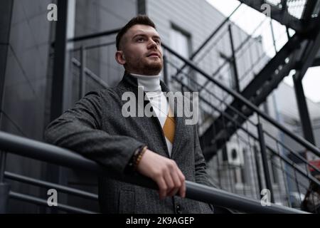Porträt eines Mannes in Geschäftskleidung auf der Treppe in der Nähe des Gebäudes, Grundsätze und Regeln eines erfolgreichen Geschäftskonzepts Stockfoto