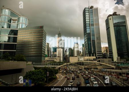 Nachmittäglicher Verkehr auf der Harcourt Road, die durch die hohen Geschäftsgebäude und Wolkenkratzer von Wan Chai, Hong Kong Island, 2017, führt Stockfoto