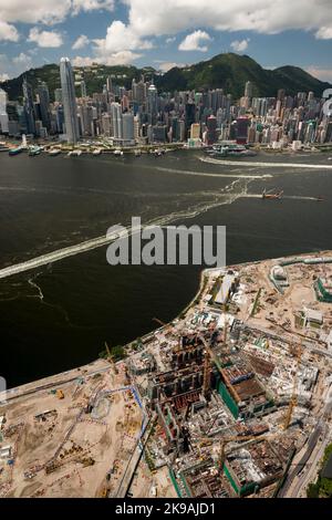 Luftaufnahme des M+ Museums, im West Kowloon Cultural District, das 2017 im Bau ist, mit Hong Kong Island, sichtbar über den Victoria Harbour Stockfoto