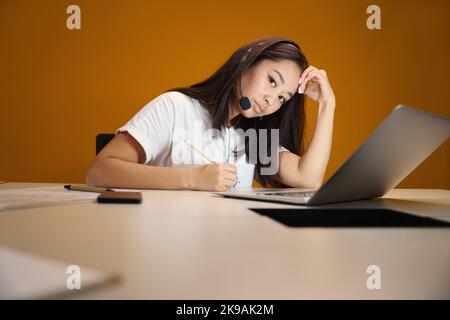 Schöne asiatische Frau während der Online-Vorstellungsgespräch im Zimmer drinnen Stockfoto