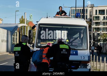 Berlin, Deutschland. 26. Oktober 2022. Eine junge Frau hat sich auf das Dach eines Polizeifahrzeugs geklebt, als Polizisten versuchen, eine Blockade der Protestgruppe der "letzten Generation" vor dem Berliner Hauptbahnhof in der Invalidenstraße zu brechen. Aktivisten hatten sich auf die Straße geklebt, um den Verkehr dort zu blockieren. Die Frau nennt sich in einem von der Gruppe veröffentlichten Video Maria und gibt ihr 18 Jahre alt. Quelle: Stefan Jaitner/dpa/Alamy Live News Stockfoto