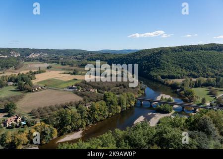 Blick auf den Fluss Dordogne, die Brücke mit mehreren Bögen und die malerische Landschaft von oben im Schloss Castelnaud-la-Chapelle, blauer Himmel Stockfoto