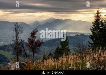 Sonnenschein durch dunkle Wolken. Wolkiger Himmel, Sonnenstrahlen. Sonnenstrahlen am bewölkten Himmel. Stockfoto