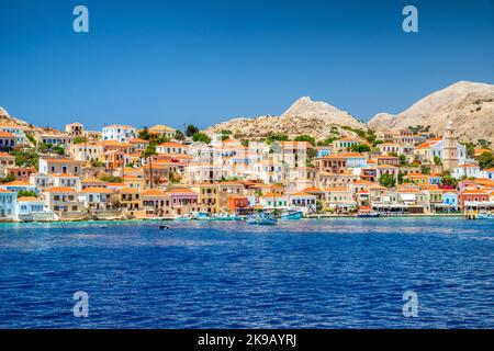 Halki, Griechenland - 6. Juli 2022: Bunte Häuser auf der kleinen malerischen Insel Halki in der Ägäis, Teil der dodekanischen Inseln in Griechenland Stockfoto