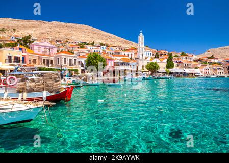 Halki, Griechenland - 6. Juli 2022: Bunte Häuser und Fischerboote auf der malerischen kleinen Insel Halki (Chalki) in Griechenland Stockfoto
