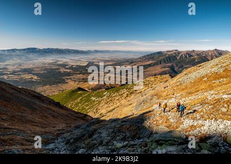 PODBANSKE, SLOWAKEI - 31. OKTOBER 2021: Touristen wandern auf dem Bergweg zum Gipfel Krivan in der Hohen Tatra. Westliche Tatra im Hintergrund Stockfoto