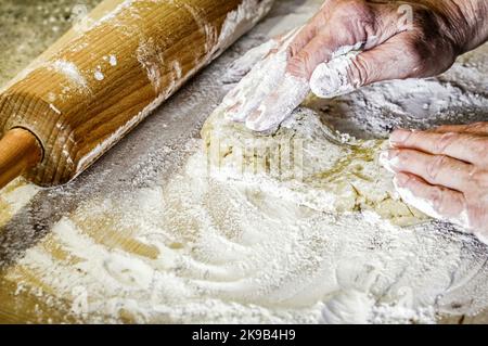 Frau Knetmasse auf dem Tisch. Holzpfeifholz im Hintergrund. Nahaufnahme. Stockfoto