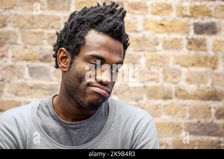 Emotionen und Ausdrücke: Erbitterung. Eine ungeduldige Atemausatmung eines gleichgültigen jungen Mannes. Aus einer Reihe verwandter Bilder. Stockfoto