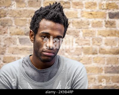 Emotionen und Ausdrücke: Apathie. Ein müder und gleichgültiger Ausdruck auf dem Gesicht eines jungen Mannes. Aus einer Reihe verwandter Bilder. Stockfoto