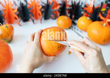 Halloween am 31. Oktober. Der Schritt-für-Schritt-Prozess des Schnitzens eines Kürbisses. Blick von oben Stockfoto